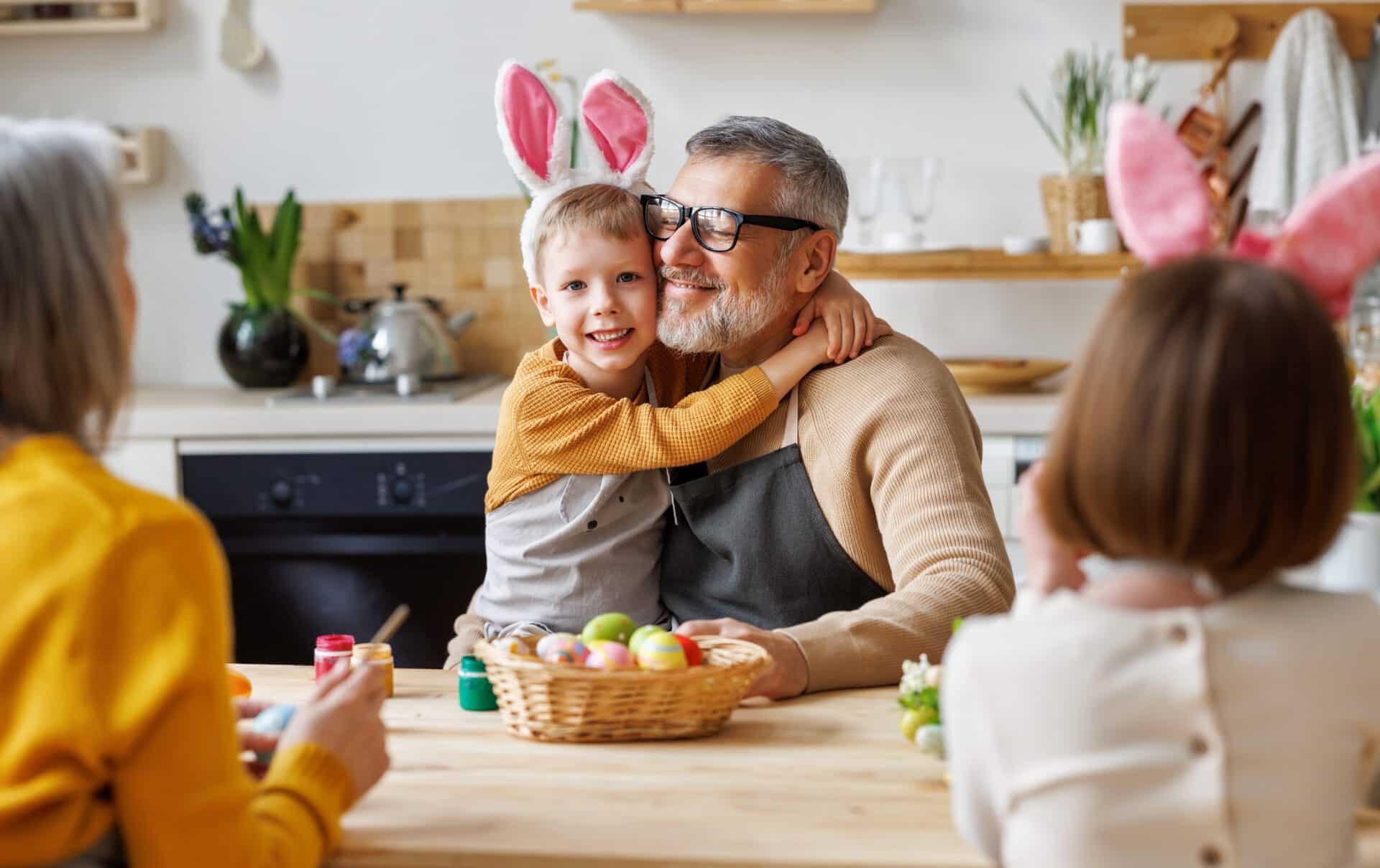 Happy family grandfather and little grandson holding wicker basket full of painted boiled eggs