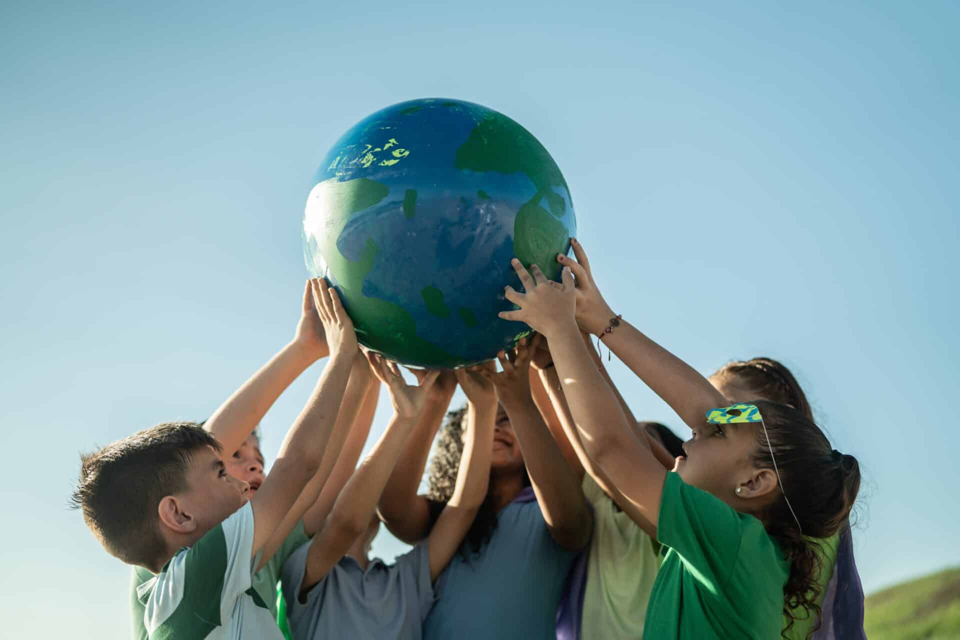 Children holding a planet outdoors