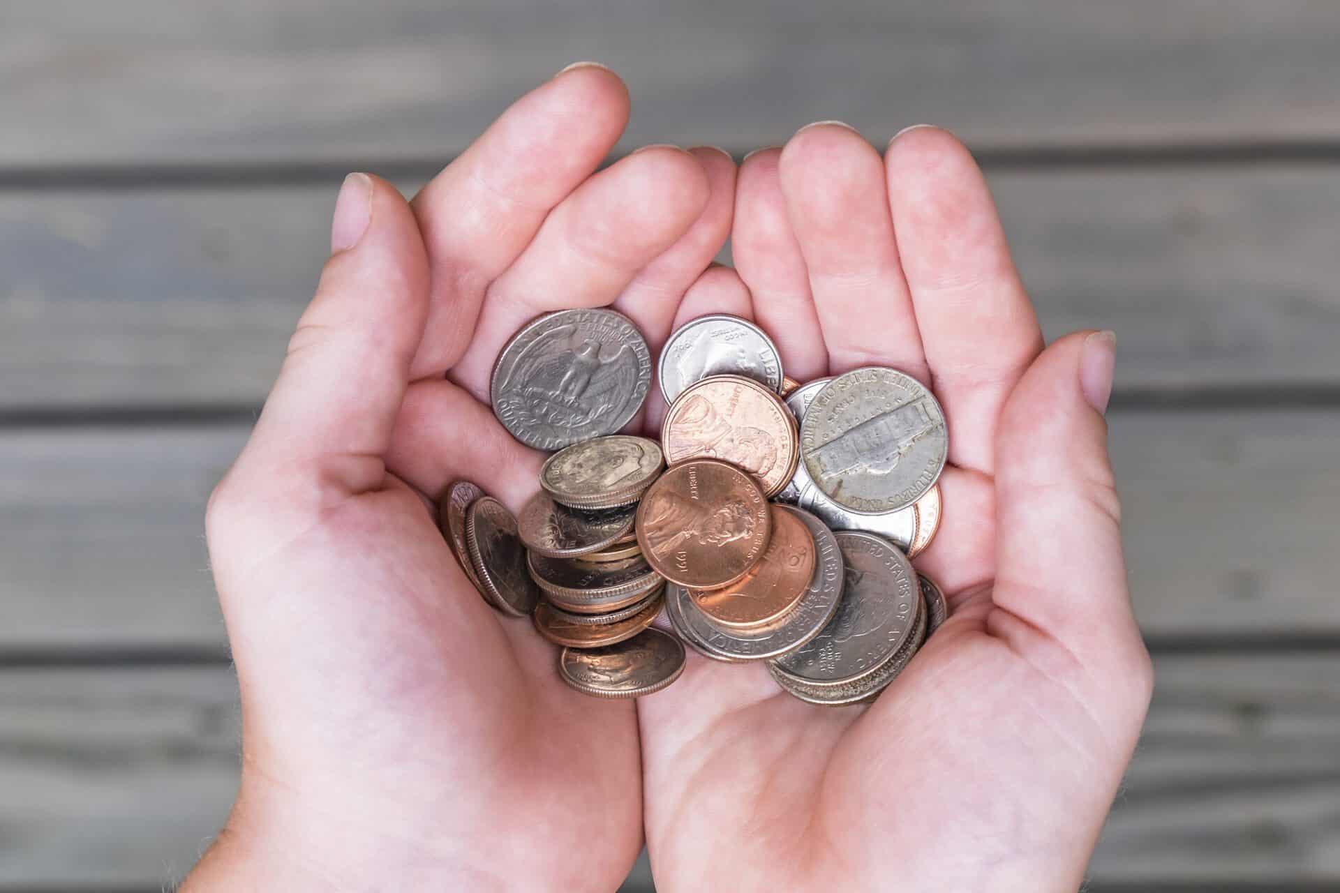 Young boy offers collection of US coins in cupped hands